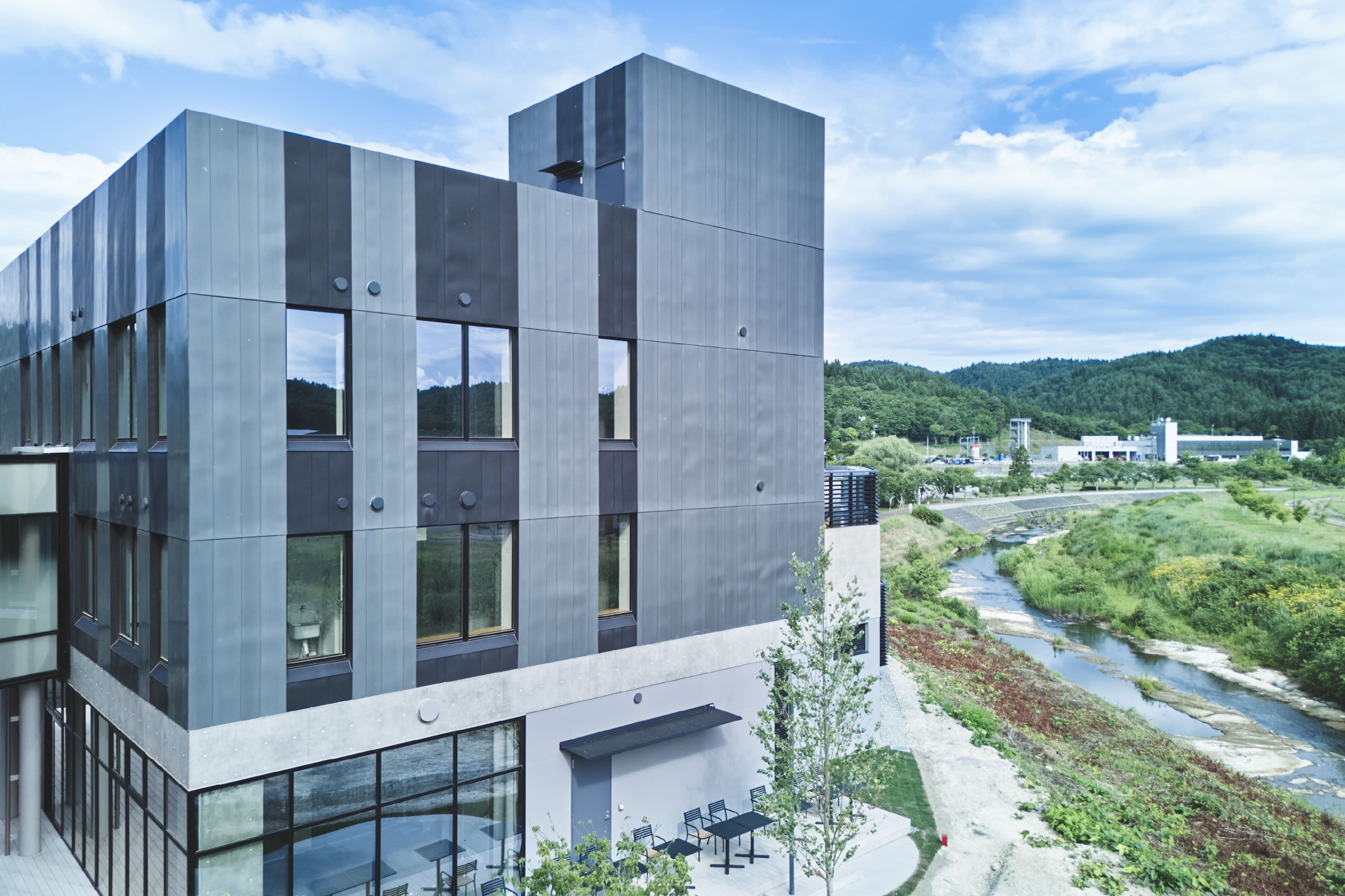 川沿いに建つ青い外壁のnooqu多階建て施設