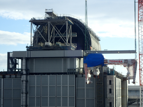 完成した燃料取扱機は大型クレーンで吊り上げられ、巨大な円筒状の燃料取り出し用カバー内に設定された（2017年11月撮影）